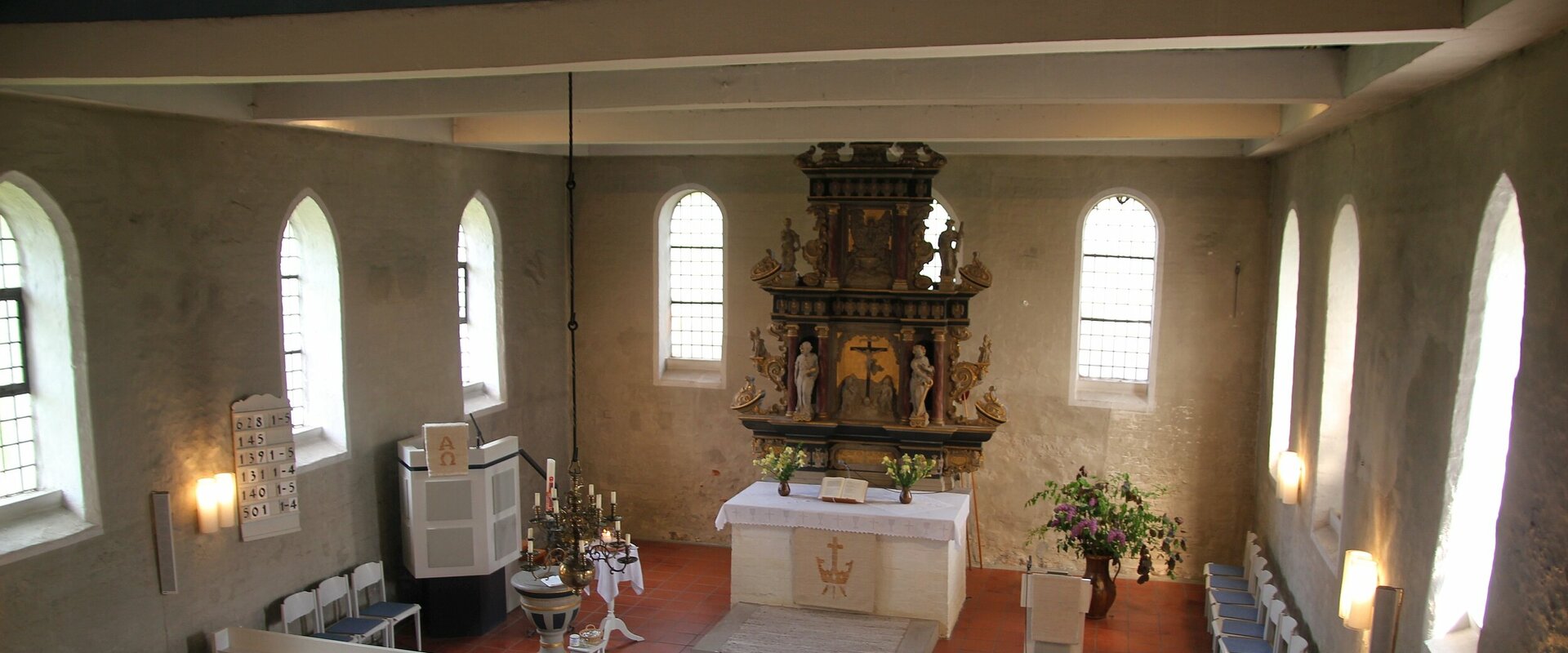 Blick in den Altarraum der St.-Georgs-Kirche in Baum und den 1656 von der Gutseigentümerfamilie Meding gestiften frühbarocken Altaraufsatz wurde aus Wesersandstein.